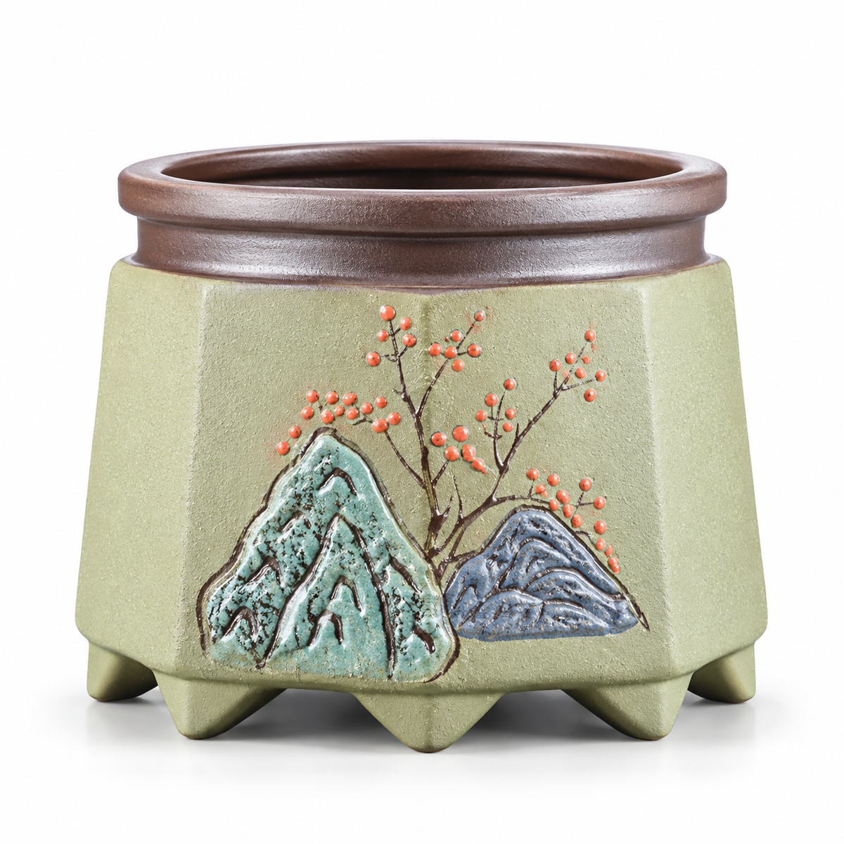 A ceramic planter pot with a light green body, a dark brown rim, and a relief decoration of two mountains and a flowering branch with orange blossoms.