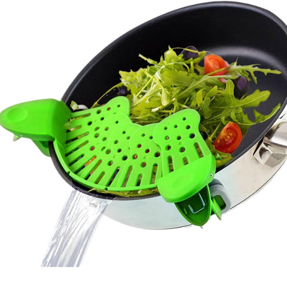 Green kitchen tool on a frying pan with vegetables