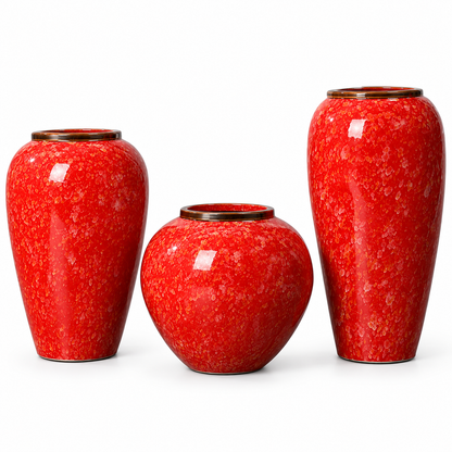 Three glossy red ceramic vases with a mottled speckled pattern and dark rims, arranged on a clean white background.